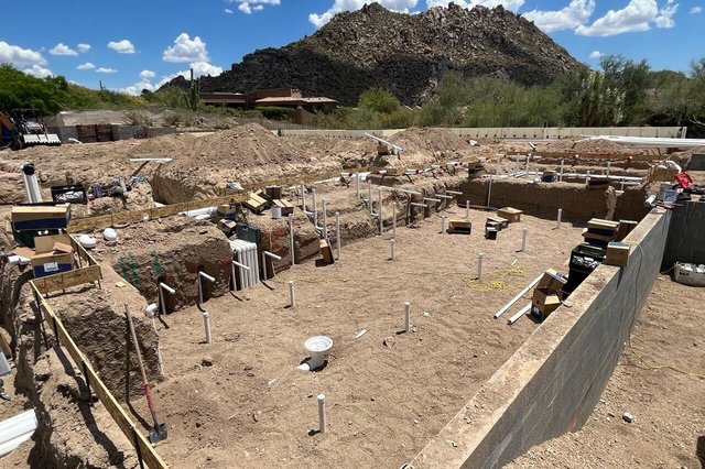 The excavated pool and spa shell with plumbing stubs and block walls in place