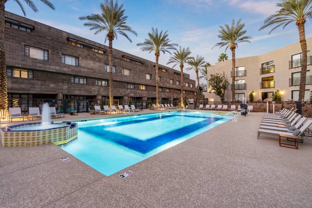 Commercial resort-style hotel pool with fountain spa and palm trees