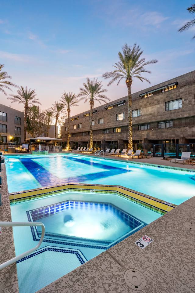 Resort hotel spa with blue glass tile and a large rectangular pool at dusk