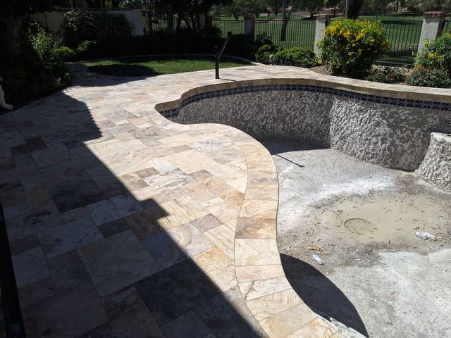 Pool renovation in progress with new travertine deck and shaded interior
